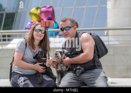 Couple qui avec leur famille Selfies chien de compagnie, à l'extérieur du Musée Guggenheim, Bilbao, Biscaye, Pays Basque, Espagne,