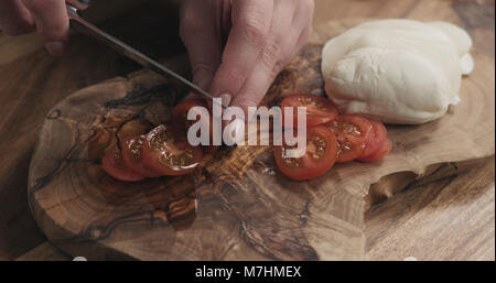 Les jeunes femmes en tranches de tomate cerise sur planche de bois, wode photo Banque D'Images