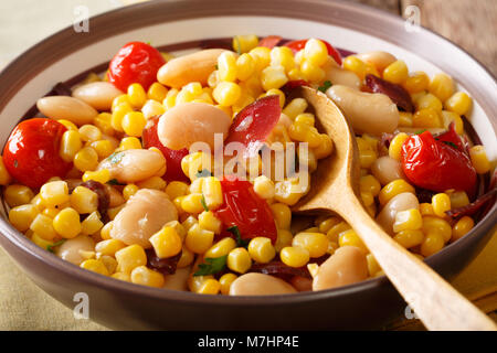 Succotash Salade de haricots beurre, tomates, poivrons et lardons macro dans un bol sur la table horizontale. Banque D'Images