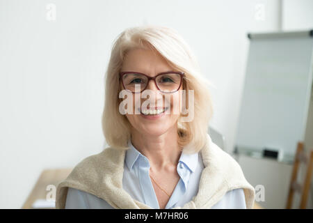 Smiling attractive senior businesswoman wearing glasses head sho Banque D'Images