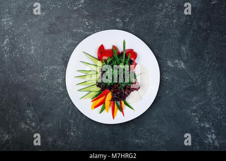 Le fromage de chèvre avec des tranches de légumes servi sur la plaque blanche. Banque D'Images