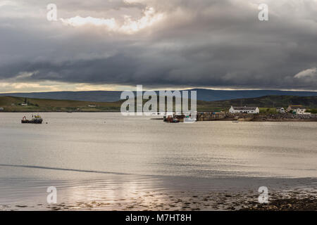 Aultbea, ÉCOSSE - 8 juin 2012 : eaux calmes de Loch Ewe avec la jetée et le port de Aultbea sous des pluies sombres nuages. Bateau de pêche. Green Hills Banque D'Images