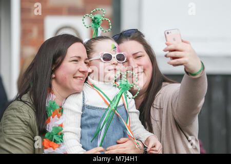 La communauté irlandaise de Birmingham célèbre la St Patrick's Day avec leur défilé annuel à travers les rues de la ville. Défilé de la ville est la troisième plus grande au monde, derrière New York et Dublin. Un enfant est habillé décoré de trèfles, tout en ayant une prise selfies. Banque D'Images