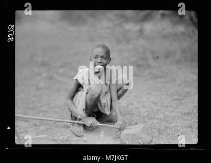 La colonie du Kenya. Namanga, réserve de chasse du sud. Garçon natif sa lance d'affûtage matpc LOC.17640 Banque D'Images