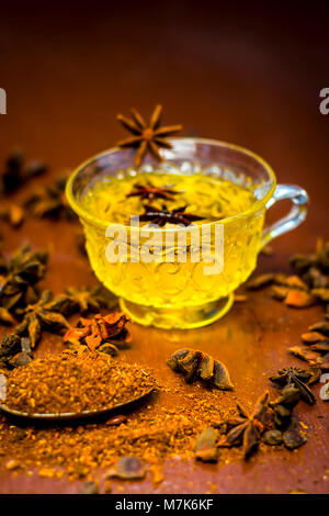 Illicium verum, star de graines d'anis dans un bol en verre.sa poudre et son plateau sur la surface en bois. Banque D'Images