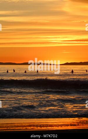 Coucher du soleil orange avec des silhouettes d'internautes Banque D'Images