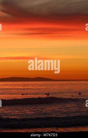 Coucher du soleil orange avec des silhouettes d'internautes Banque D'Images