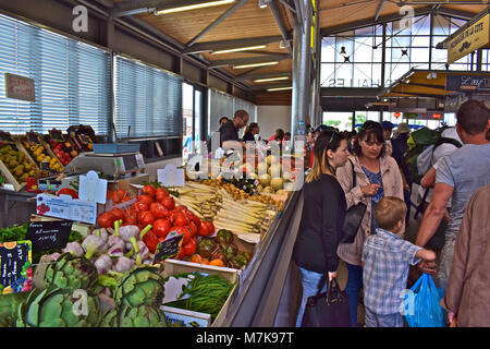 Groupe Famille shopping à un étal de fruits et légumes dans la halle de Bretignolles-sur-Mer en Vendée de France. Banque D'Images