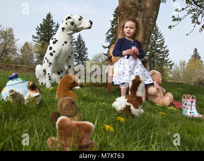 Une jeune fille (3-5 ans) ayant un thé avec ses amis animaux en peluche. Banque D'Images