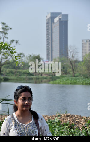 Bengali dame debout en face d'un lac avec une tour dans son dos outdoor Banque D'Images