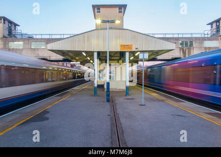 La gare de Woking à Surrey avec les trains d'assaut passé les plates-formes sur leur chemin à et de Londres Banque D'Images