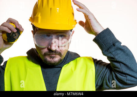 Passe-temps d'un homme qui veut faire un travail sans connaissance, sans expérience de travail. Faire vous-même, l'homme habillé en jaune builder casque avec gl de protection Banque D'Images