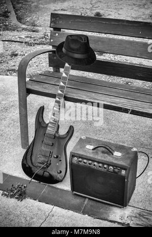 Vieille guitare et l'amplificateur à côté d'un banc de parc, un concept de la musique de rue Banque D'Images