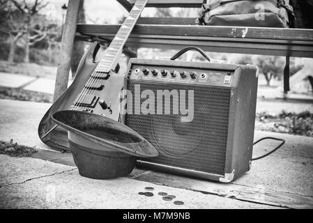 Vieille guitare et l'amplificateur à côté d'un banc de parc, un concept de la musique de rue Banque D'Images