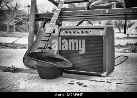 Vieille guitare et l'amplificateur à côté d'un banc de parc, un concept de la musique de rue Banque D'Images