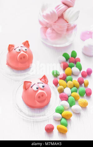 Délicate de macarons sucrés massepain rose sous la forme d'un mini-guimauves de porc, arachides en sucre couleurs pastel sur un fond clair avec place pour Banque D'Images