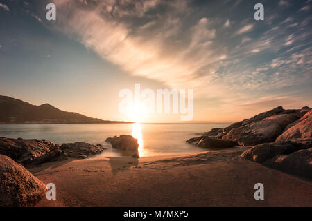 Coucher du soleil sur l'éperon rocheux et plage de sable à Algajola en Balagne Corse Banque D'Images