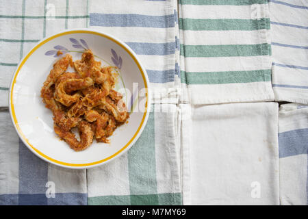 Les tripes de style romain avec la sauce tomate dans un plat sur quelques serviettes colorées Banque D'Images