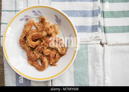 Les tripes de style romain avec la sauce tomate dans un plat sur quelques serviettes colorées Banque D'Images