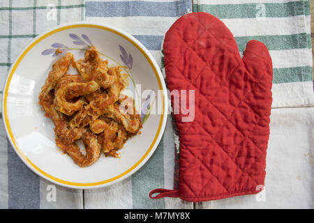 Les tripes de style romain avec la sauce tomate dans un plat sur quelques serviettes colorées Banque D'Images