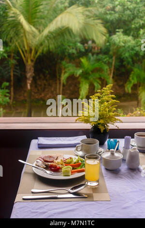 Petit-déjeuner avec vue sur le jardin de la jungle dans le pèlerinage Hotel, Hue, Vietnam Banque D'Images