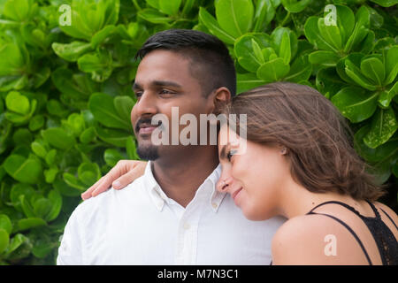 Jeune couple heureux mélange couru sur fond vert. Banque D'Images