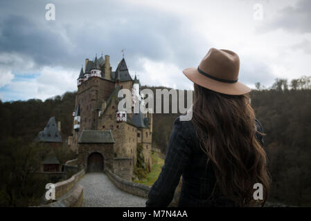 Jeune femme méconnaissable promenades le long chemin menant à un château incroyable. La place médiévale romantique. Les rayons de soleil tombent sur les cheveux. Girl voyager en Europe Banque D'Images