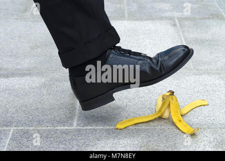 Businessman sur le point d'étape sur une peau de banane Banque D'Images