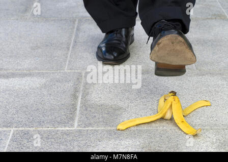 Businessman sur le point d'étape sur une peau de banane Banque D'Images