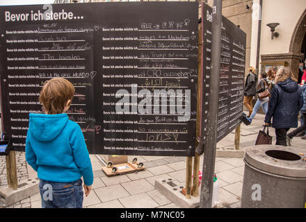 Germany-March,10,2018 : Un garçon lit un tableau noir avec tient dans les différentes langues de choses à faire avant la mort Banque D'Images