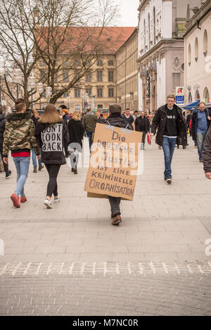 Germany-March,10,2018 : un homme marchant dans la zone piétonne de Munich porte une signature manuscrite en allemand pour protester contre la corruption en allemand Banque D'Images