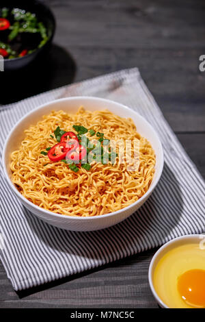 Les nouilles instantanées avec des œufs dans des bols en bois Banque D'Images