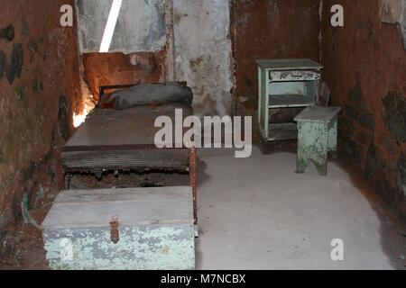 Une ancienne cellule de prison avec lit et bureau Banque D'Images
