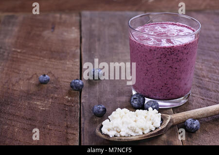 Les grains de kéfir dans la cuillère en bois en face de kéfir de bleuets Smoothie. Le kéfir est un des meilleurs aliments santé disponible à un puissant probiotiques. Banque D'Images