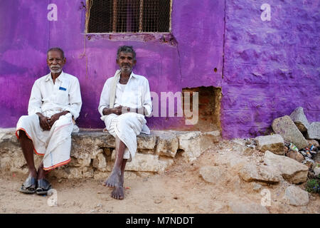 KAMALAPURAM, INDE - 02 février 2015 : les hommes indiens locaux et de socialisation au repos sur la rue en face d'une couleur violette accueil. Banque D'Images