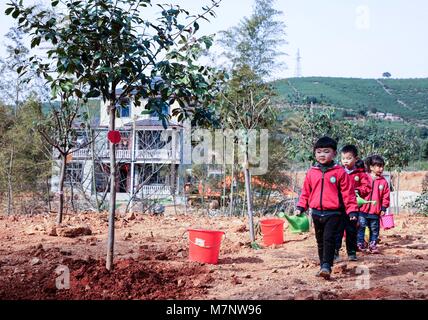 Changxing, Province de Zhejiang en Chine. 12Th Mar, 2018. Les enfants apportent de l'eau pendant une activité de plantation à l'Lijiaxiang Canton de Changxing County, Zhejiang Province de Chine orientale, le 12 mars 2018. Une activité de plantation visant à favoriser la sensibilisation des enfants à la protection de l'environnement a eu lieu ici. Credit : Xu Xu/Xinhua/Alamy Live News Banque D'Images