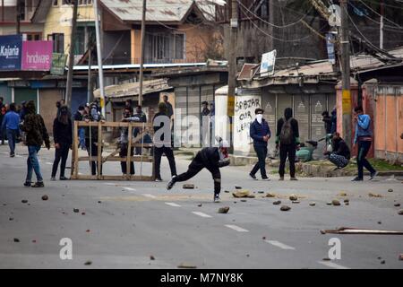 Srinagar, au Cachemire. 12 mars, 2018. Les manifestants jettent des pierres en direction du Cachemire police indienne au cours d'affrontements dans la région de Srinagar, Cachemire sous administration indienne. Au milieu des affrontements, des milliers de personnes ont participé dans les derniers sacrements de l'Eesa Fazili, un étudiant en ingénierie tourné militant. Jésus n'a été tué dans une fusillade brève le long avec deux associés dans Hakoora Kashmirâ sud du village, district d'Anantnag plus tôt aujourd'hui. n au milieu pro-liberté et anti-Inde de crédit : ZUMA Press, Inc./Alamy Live News Banque D'Images