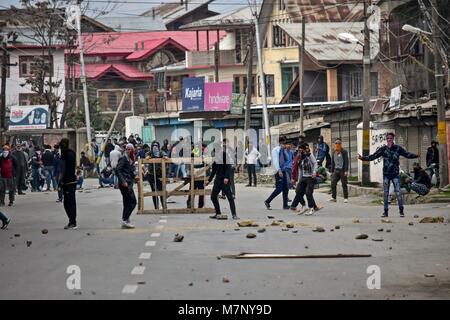 Srinagar, au Cachemire. 12 mars, 2018. Les manifestants du Cachemire indien en conflit avec la police lors d'une manifestation à Srinagar, Cachemire sous administration indienne. Au milieu des affrontements, des milliers de personnes ont participé dans les derniers sacrements de l'Eesa Fazili, un étudiant en ingénierie tourné militant. Jésus n'a été tué dans une fusillade brève le long avec deux associés dans Hakoora Kashmirâ sud du village, district d'Anantnag plus tôt aujourd'hui. n au milieu pro-liberté et de slogans anti-Inde. ( Crédit : ZUMA Press, Inc./Alamy Live News Banque D'Images