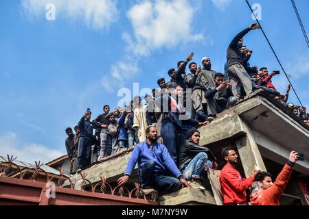 Srinagar, au Cachemire. 12 mars, 2018. Les habitants du Cachemire regarder la procession funéraire de l'Eesa Fazili, un étudiant en ingénierie tourné à Srinagar, militant du Cachemire indien. Au milieu des affrontements, des milliers de personnes ont participé dans les derniers sacrements de l'Eesa Fazili, un étudiant en ingénierie tourné militant. Jésus n'a été tué dans une fusillade brève le long avec deux associés dans Hakoora Kashmirâ sud du village, district d'Anantnag plus tôt aujourd'hui. n Crédit : ZUMA Press, Inc./Alamy Live News Banque D'Images