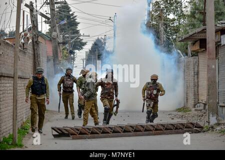 Srinagar, au Cachemire. 12 mars, 2018. Les policiers indiens Run for Cover lors d'affrontements dans la région de Srinagar, Cachemire sous administration indienne. Au milieu des affrontements, des milliers de personnes ont participé dans les derniers sacrements de l'Eesa Fazili, un étudiant en ingénierie tourné militant. Jésus n'a été tué dans une fusillade brève le long avec deux associés dans Hakoora Kashmirâ sud du village, district d'Anantnag plus tôt aujourd'hui. Image : © Crédit photo : ZUMA Press, Inc./Alamy Live News Banque D'Images