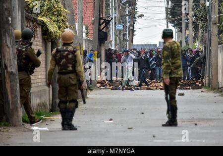 Srinagar, au Cachemire. 12 mars, 2018. Les manifestants du Cachemire indien en conflit avec la police lors d'une manifestation à Srinagar, Cachemire sous administration indienne. Au milieu des affrontements, des milliers de personnes ont participé dans les derniers sacrements de l'Eesa Fazili, un étudiant en ingénierie tourné militant. Jésus n'a été tué dans une fusillade brève le long avec deux associés dans Hakoora Kashmirâ sud du village, district d'Anantnag plus tôt aujourd'hui. n au milieu pro-liberté et de slogans anti-Inde. ( Crédit : ZUMA Press, Inc./Alamy Live News Banque D'Images