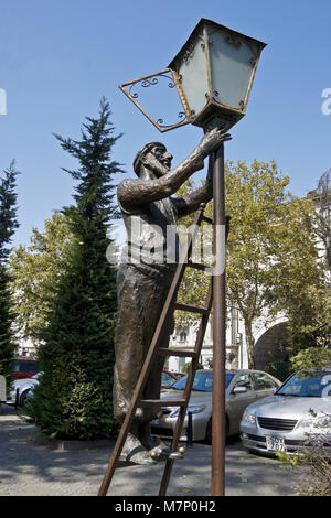 Sculpture en bronze d'un homme debout sur une échelle d'allumer une lampe de rue, Tbilissi, Géorgie Banque D'Images