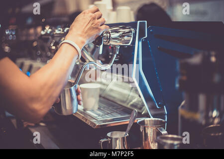 Pichet de lait Barista holding des flux pour le café Banque D'Images