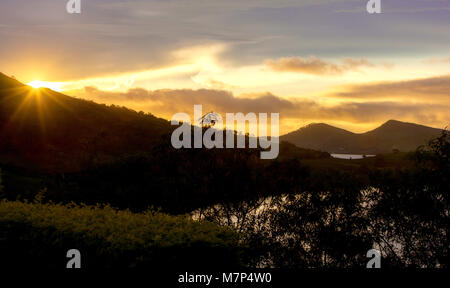 Coucher du soleil sur l'île de Fidji tropical donnant sur les buissons, Océan Atlantique et les collines. Deux collines sont en arrière-plan. Reflet de couleurs orange chaud calme sur wa Banque D'Images