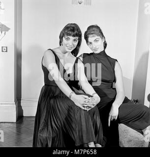 Joan Collins, actrice, 22 ans, photographiée en soie noire robe de cocktail, à son appartement à Marylebone, Londres, 10 février 1954. Photo-call après 10 mois de séjour à Hollywood. En photo avec jeune sœur Jackie Collins. Banque D'Images