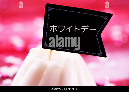 Un gâteau blanc surmonté d'une pancarte en forme de drapeau avec le jour blanc texte écrit en japonais, la populaire fête asiatique observé par les femmes qui se présentent Banque D'Images