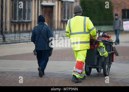 Street Sweeper marche le long de la route de l'image en poussant et gris avec barrow bâtiment s en arrière-plan Banque D'Images