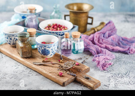 Assortiment d'herbes médicinales à sec les bourgeons roses et la lavande dans des bols. Banque D'Images