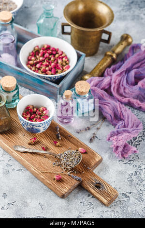 Assortiment d'herbes médicinales à sec les bourgeons roses et la lavande dans des bols. Banque D'Images