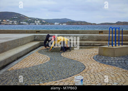 Finikas Bay : Mars 12 . Des tailleurs de pierre la préparation de la conception de mosaïque en pierre dans un lieu public square.. Finikas, 12 mars 2018, Syros, Grèce. Banque D'Images